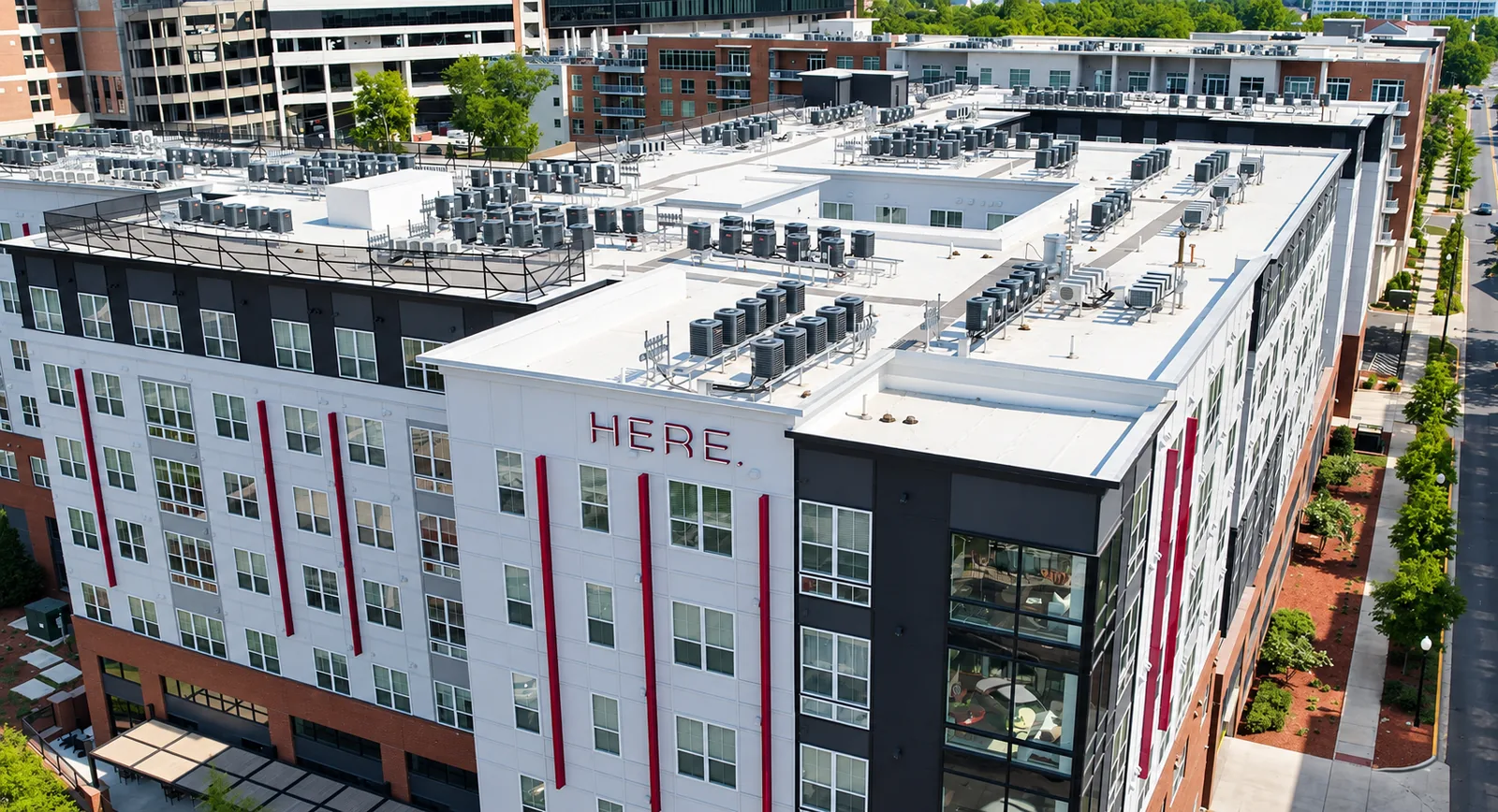 Rows of apartment HVAC condensing units installed on a multifamily rooftop in Tuscaloosa