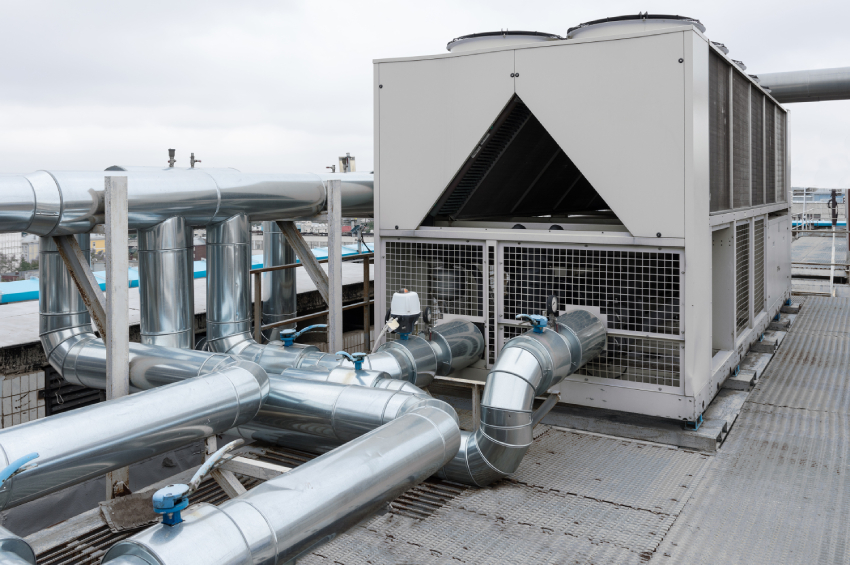 Rooftop air-cooled chiller with galvanized steel piping on a commercial building